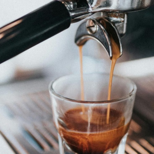 a shot of espresso being pulled from a machine